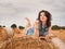 Beautiful Woman Reading book on a haystack, nature background