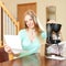 Beautiful woman reading warranty card for new coffee machine a