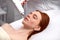Beautiful woman receiving facial microcurrent treatment by beauty therapist