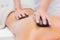 Beautiful woman receiving stone massage at spa center