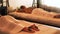 Beautiful woman receiving stone massage in spa resort. Young woman relaxing while back massage with hot stone. Spa
