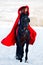 Beautiful woman with red cloak with horse outdoor in winter