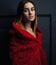 Beautiful woman red cloak with red flowers roses in studio