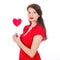 Beautiful woman in red dress with red heart-shaped lollipop