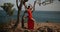Beautiful woman in red dress on the sea shore cliff during over sea and sky background