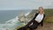 Beautiful woman relaxes at Cabo da Roca in Portugal - Sintra Natural Park