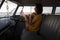 Beautiful woman relaxing in camper van with his foot outside against beach in background