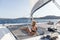 Beautiful woman relaxing on a summer sailing cruise, lying and sunbathing in hammock of luxury catamaran sailing around