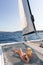 Beautiful woman relaxing on a summer sailing cruise, lying and sunbathing in hammock of luxury catamaran sailing around