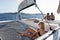 Beautiful woman relaxing on a summer sailing cruise, lying and sunbathing in hammock of luxury catamaran sailing around