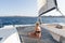 Beautiful woman relaxing on a summer sailing cruise, sitting and sunbathing in hammock of luxury catamaran sailing