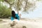 Beautiful woman relaxing on wooden swing under tree