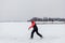 Beautiful woman rides on lake. Young woman in winter clothes enjoys figure skating on frozen ice on frosty day