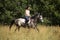 Beautiful woman riding gray horse in the forest