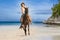 Beautiful woman riding a horse on tropical beach