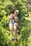 Beautiful woman riding a zip line in a lush tropical forest