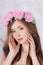 Beautiful woman in roses wreath with long hair poses