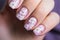 Beautiful woman\\\'s fingernails with white spring flowers on pastel pink base nail art design