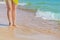 Beautiful woman`s legs on sandy beach in seawater