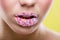 Beautiful woman\'s mouth full of colorful sugar pearls