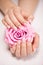 Beautiful woman\'s nails with french manicure and rose