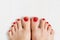 Beautiful woman& x27;s vinous burgundy nails with beautiful pedicure. Female feet with bright pedicure on white wooden