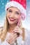 Beautiful woman with santa hat holding red -white Christmas Lollipop