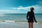 Beautiful woman at the seaside enjoying the warm breeze blowing her hair