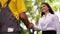 Beautiful woman shakes hands with a courier outside