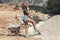 Beautiful woman in the shorts and in the red peaked cap working the construction site