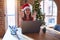 Beautiful woman sitting at the table working with laptop wearing santa claus hat at christmas relax and smiling with eyes closed