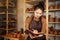 Beautiful woman sitting and writing in a notebook in a pottery workshop. potter keeps a record of business on the