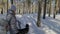 Beautiful woman and small child walking in winter forest with of husky dog. Happy young mother with daughter in the