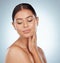 Beautiful woman with smooth glowing skin and copyspace posing topless and touching face and neck. Headshot of caucasian