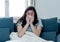 Beautiful woman sneezing suffering from cold or allergy feeling awful lying on sofa