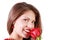 Beautiful woman sniffs red rose and looks at camera