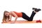 Beautiful woman in sportswear training hands, shoulders and back on a orange mat