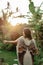 Beautiful woman standing in a garden in harmony with nature facing the sun