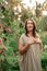 Beautiful woman standing in a garden in harmony with nature facing the sun