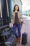 Beautiful woman standing with luggage near the vintage railcar