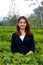 A beautiful woman stands among the tea leaves in the city of Solo - Indonesia in the afternoon.