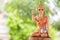 A beautiful woman statue sitting beckoning happy lot in with green nature background