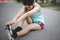 A beautiful woman stretching her body before going for a run in the morning. A female runner kicks her toe to stretch. women`s