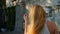 Beautiful woman styling hair outdoors. Slow Motion. Happy calm attractive girl with long healthy hair having fun in the