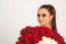 Beautiful woman with stylish makeup. Girl holds luxury big bouquet of roses. Perfect sensual lips. Fashion makeup