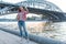 Beautiful woman summer autumn, stands summer bridge, under river. Expectation date relationship. Taking pictures himself