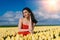Beautiful Woman in summer dres standing in colorful tulip flower fields in Amsterdam region, Holland, Netherlands