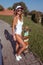 Beautiful woman sunbathes with board, skate longboard. Long hair tanned figure. Concepts fashion youth style, trend and