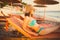 Beautiful woman sunbathing in a bikini on a beach at tropical travel resort,enjoying summer holidays.Young woman lying on sun bed