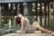 Beautiful woman in sunglasses in wooden river embankment.